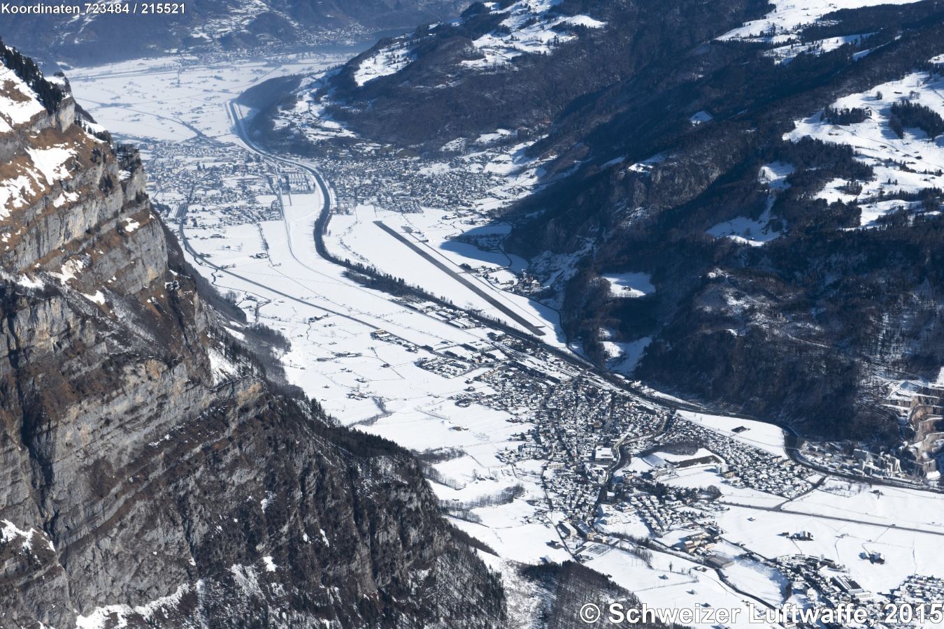 Flugplatz Mollis (Position 2'723'430.37, 1'215'933.82). Dorf südl. Flugplatz: Netstal; nördlich Flugplatz, rechts der Linth: Mollis; links der Linth: Näfels. Danach an den oberen linken Bildrand: Escherkanal zum Walensee mit Weesen im Hintergrund. - Aufnahme: Februar 2015